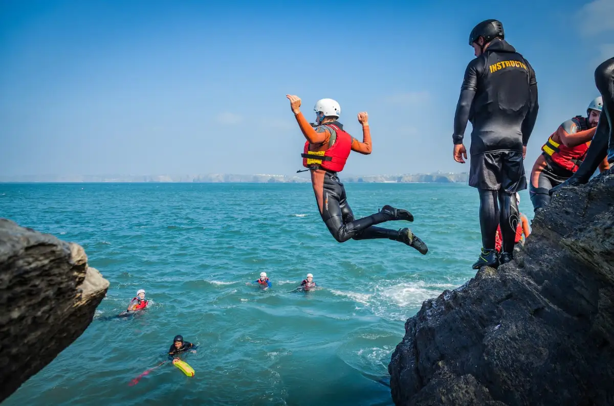 Person jumping into water during an adventure activity