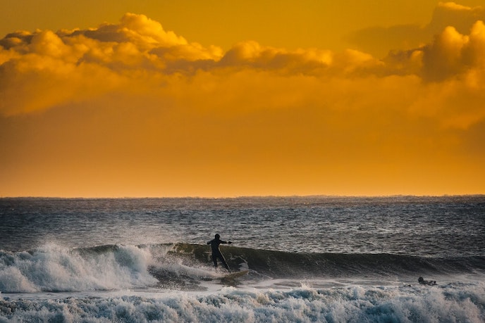 Surfer at Robin Hoods Bay, North Sea - the start of the UK coast to coast walk